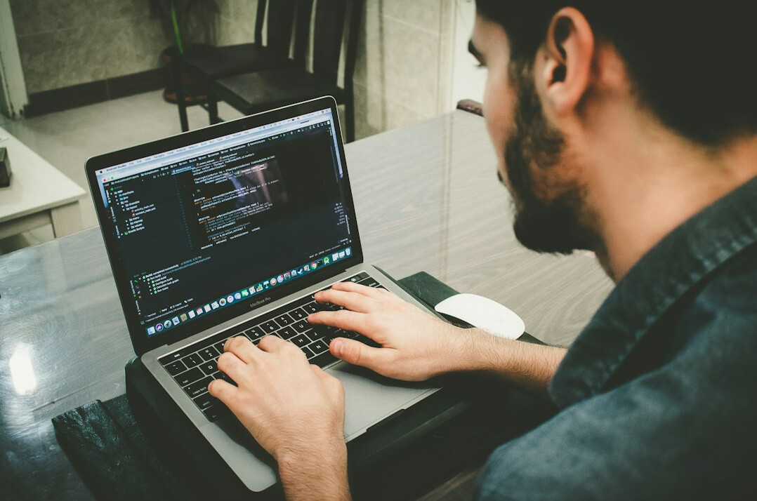 young person coding on laptop